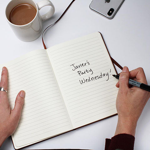 Keepsake journal open on a desk with a coffee cup